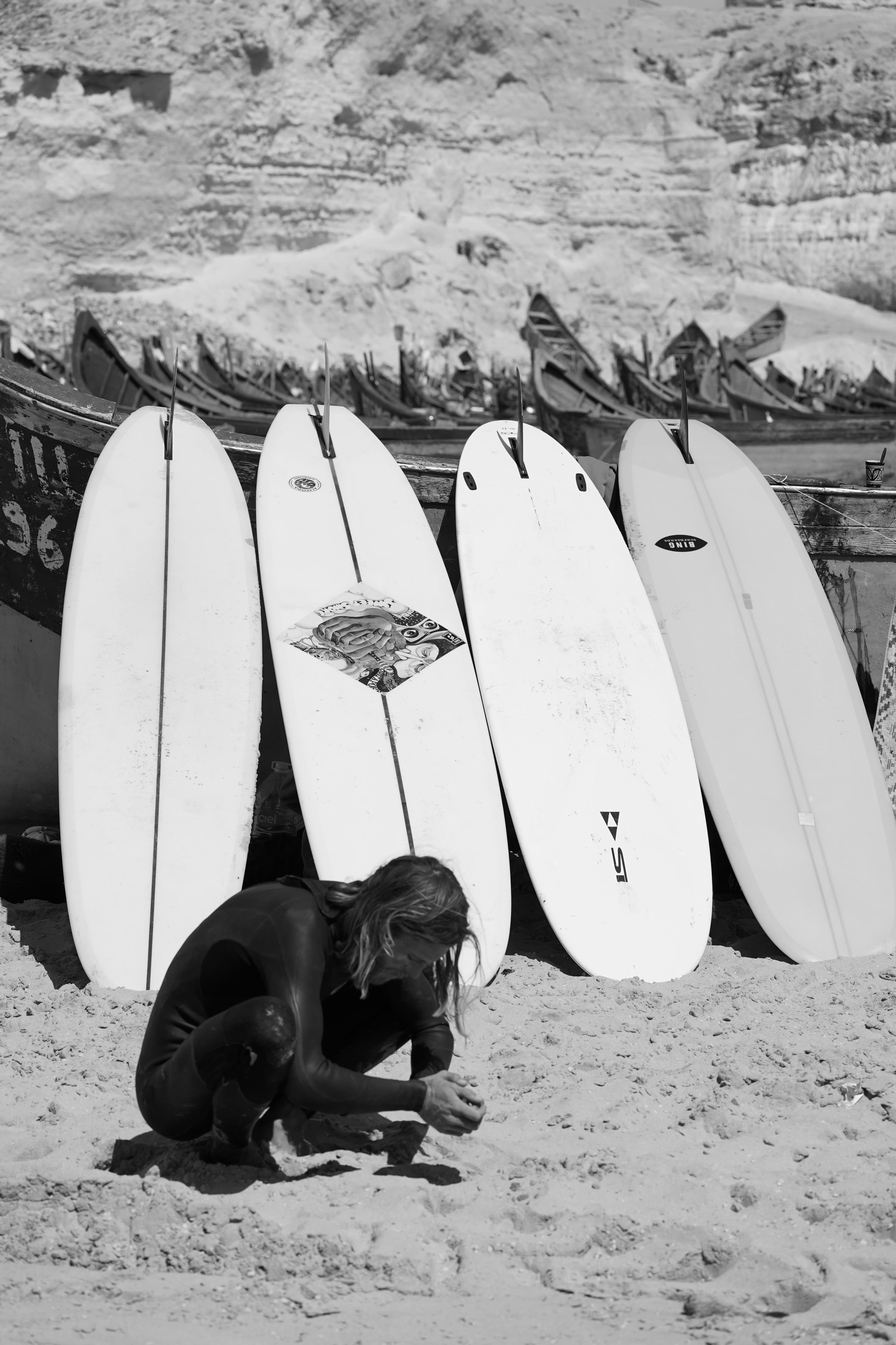Longboards lined up on the sand before a day on the coast